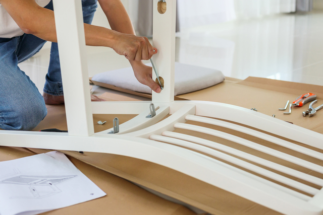 Man assembling white chair furniture at home